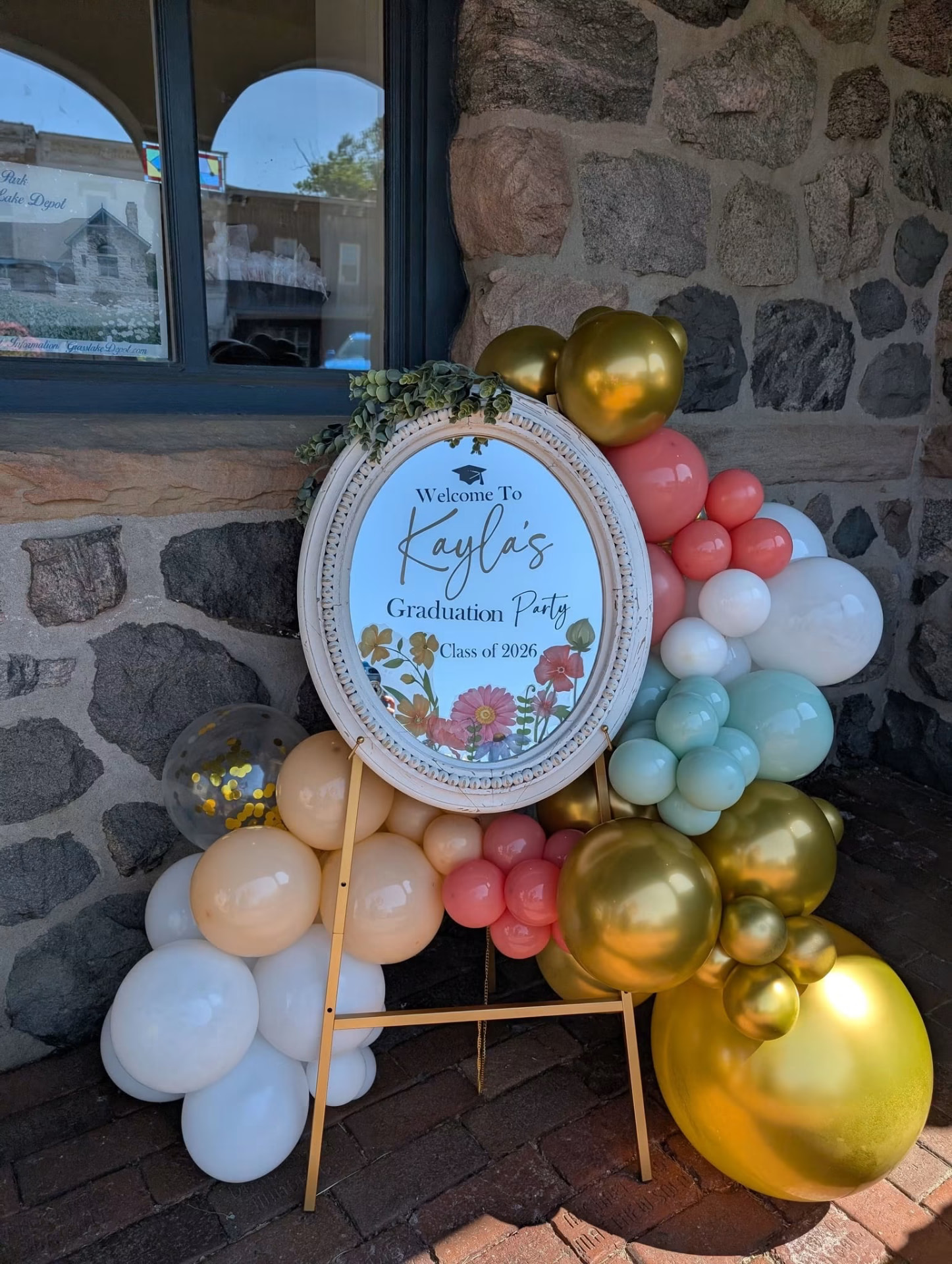 Graduation welcome sign framed with coral, gold and mint balloons