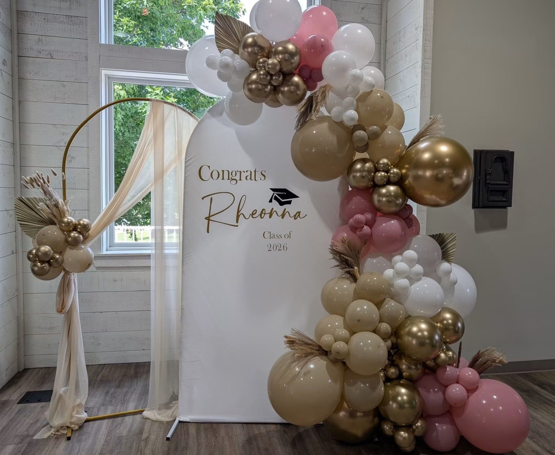 Gold, cream and pink graduation balloon arch with pampas